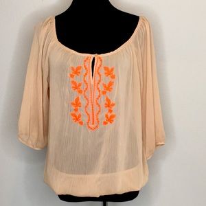 Beige sheer blouse with neon orange embroidery.